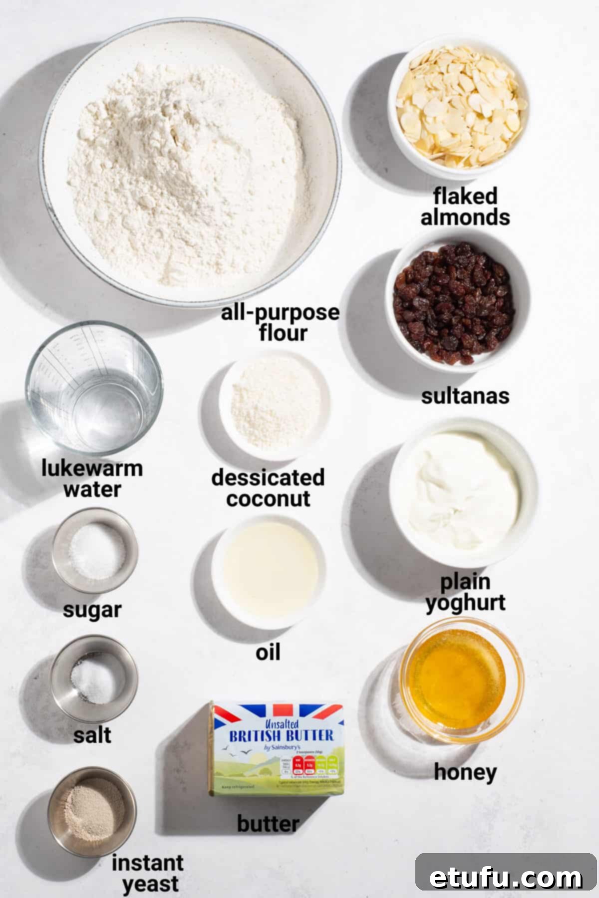 A flat lay of various ingredients for Peshwari naan, including flour, yeast, sugar, yogurt, sultanas, flaked almonds, desiccated coconut, and honey.