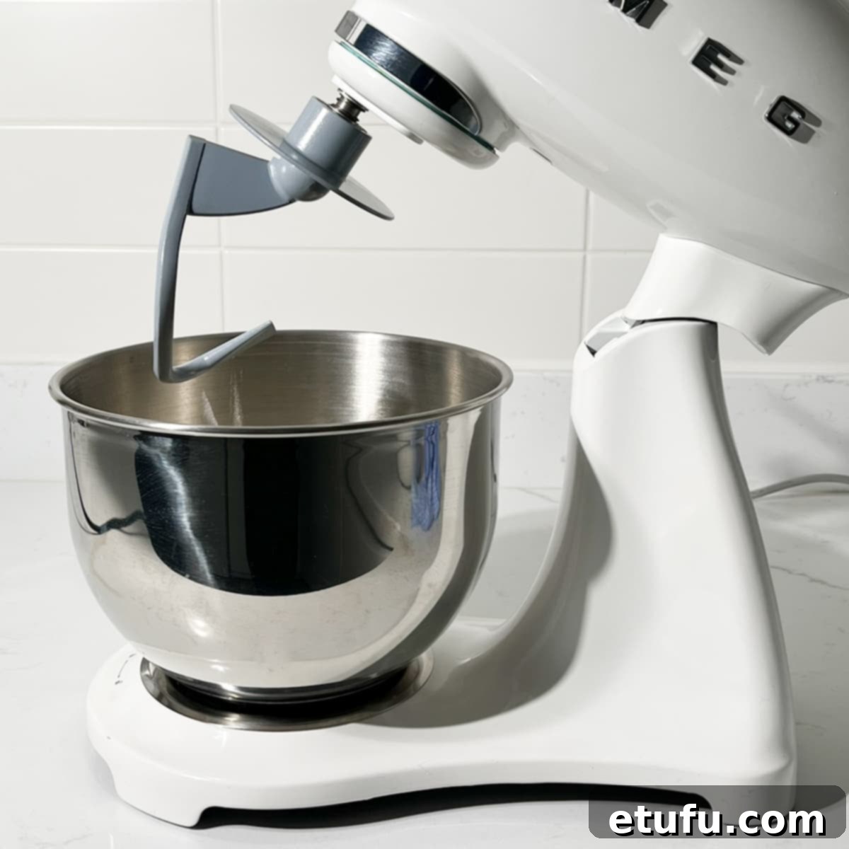 A stand mixer with a dough hook attachment being fitted.