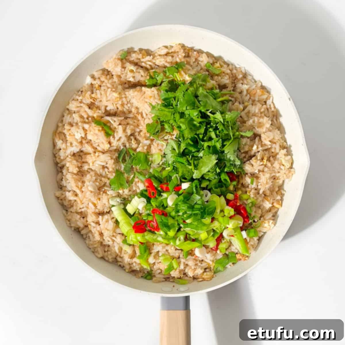 Adding the chopped coriander, chilli and spring onion to the pan.