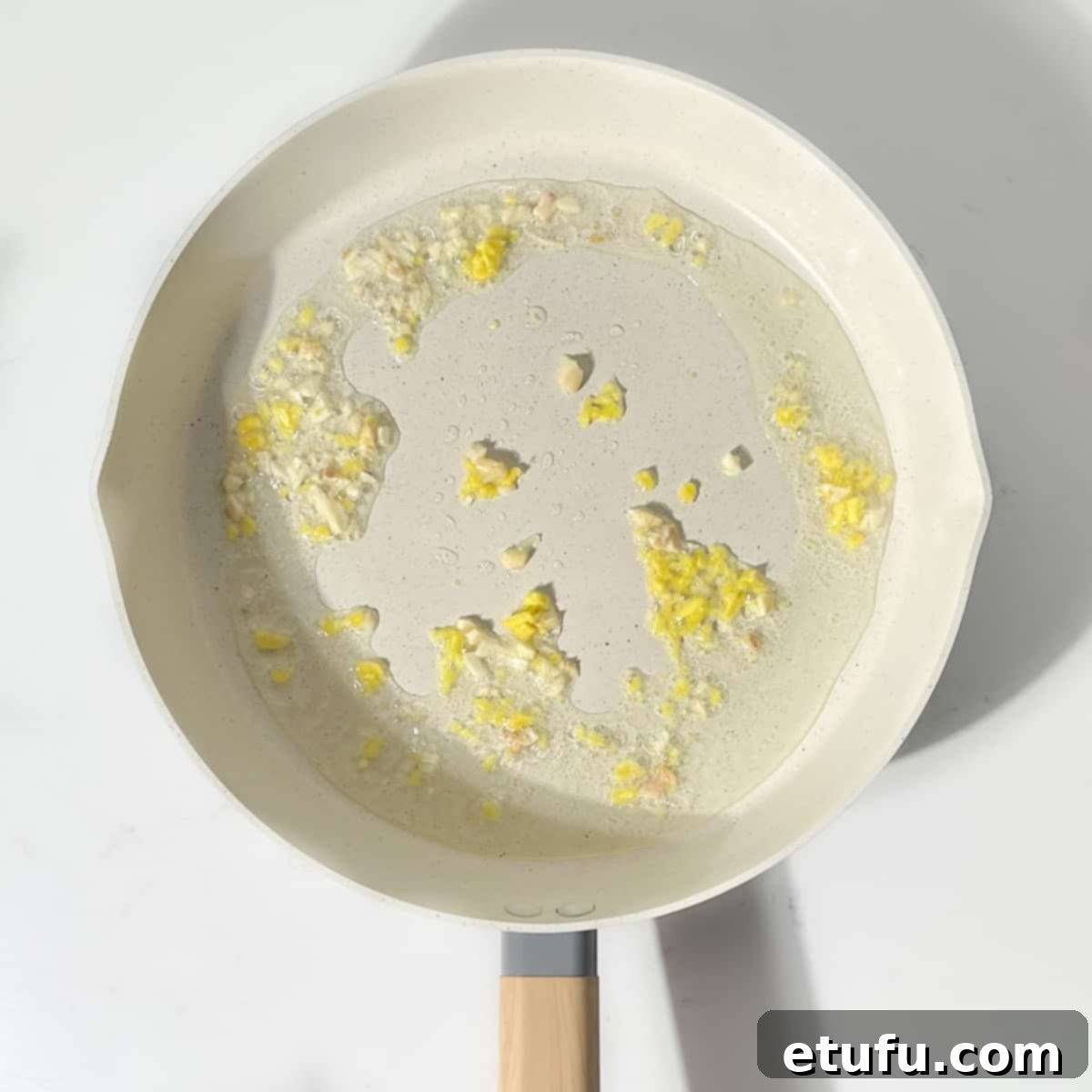 Frying the garlic and ginger for the khao pad.