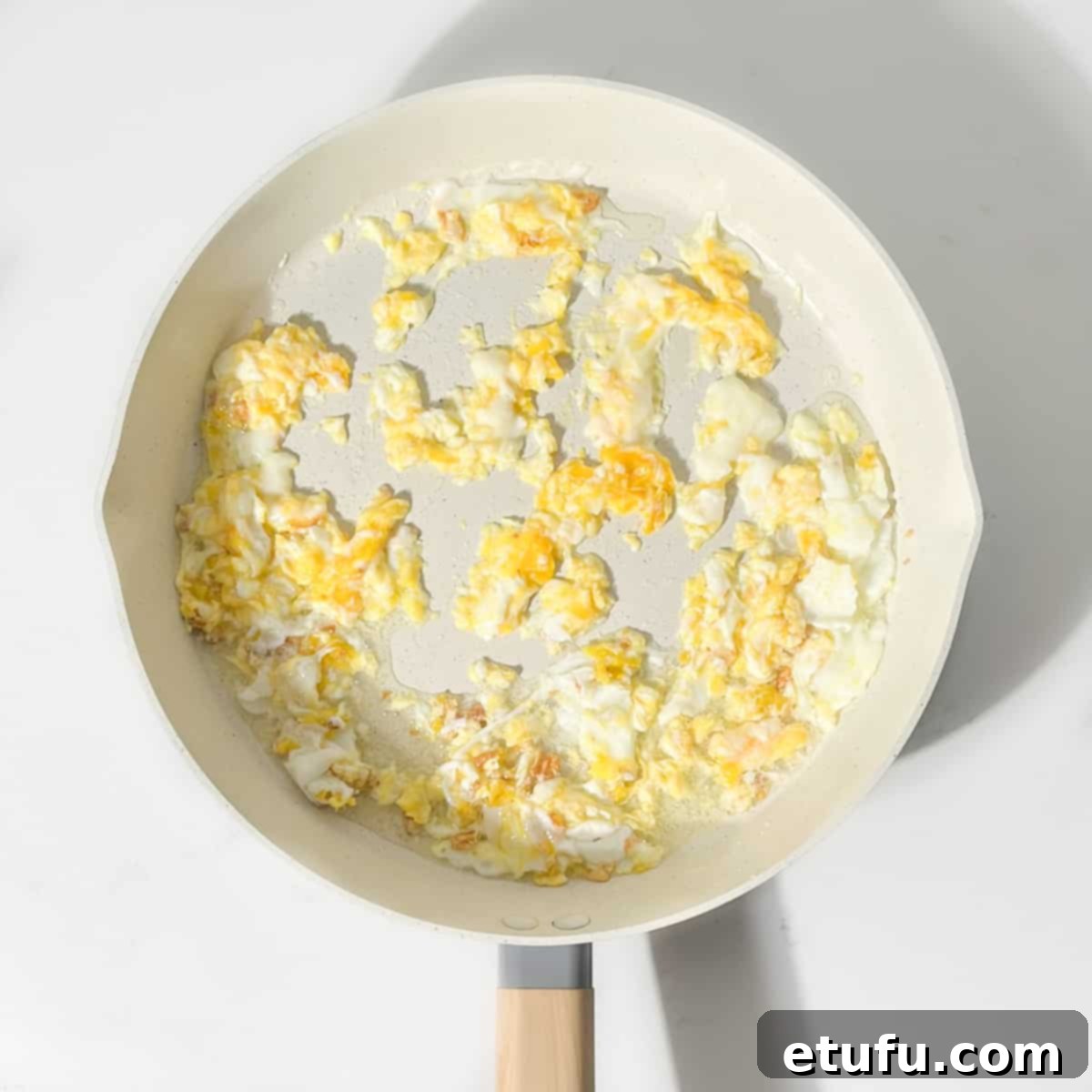 Frying the eggs until they are set in a large frying pan.