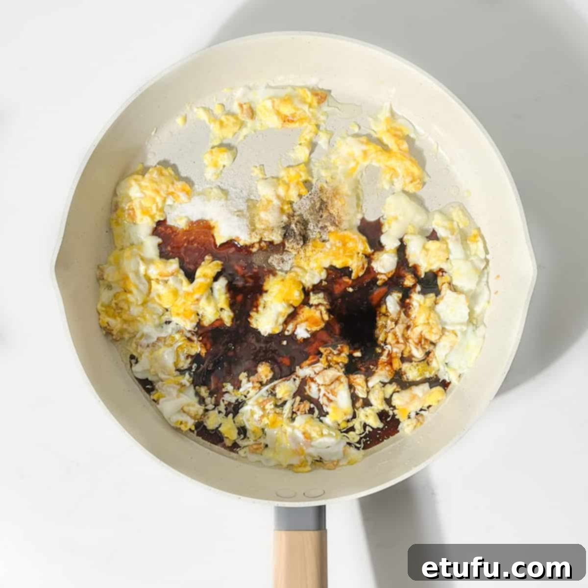 Adding the sauces for the khao pad to the pan.