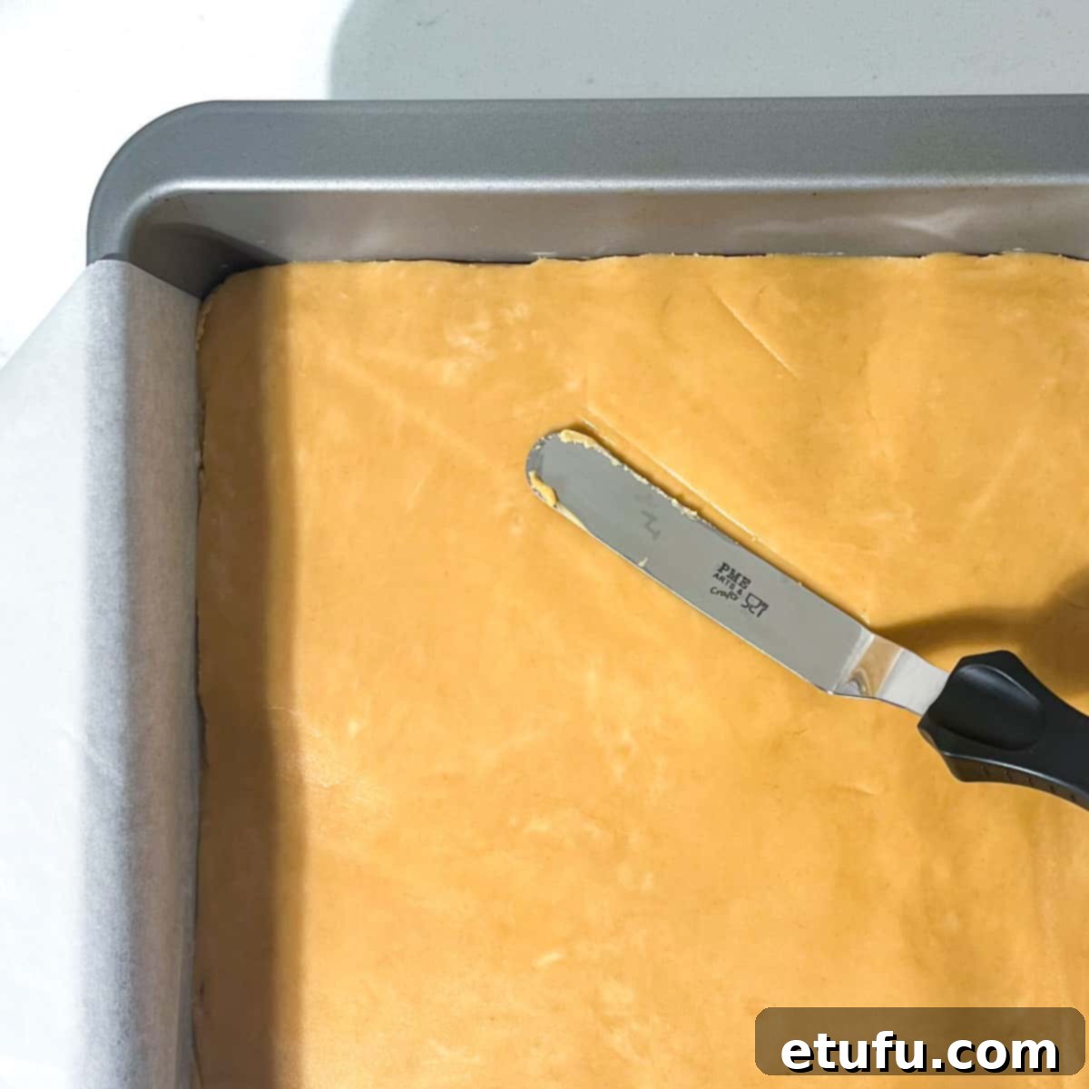 Smoothing the peanut butter fudge out with a small pallet knife.