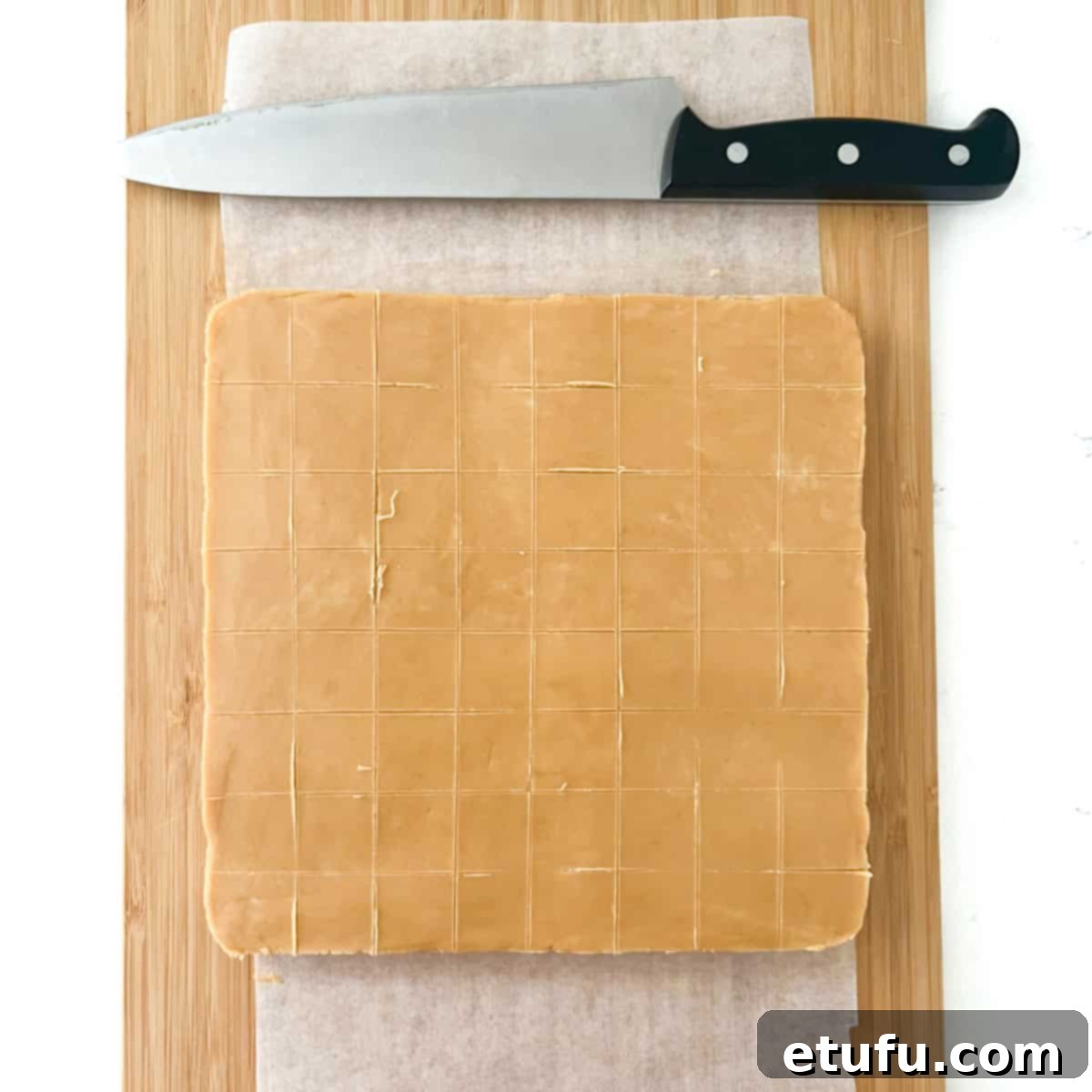 Peanut butter fudge on a chopping board with score lines for cutting.