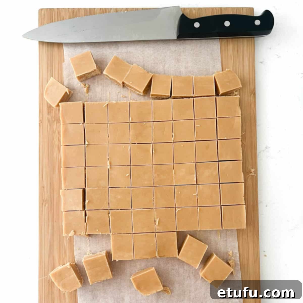 Peanut butter fudge on a chopping board, slice into small slices.