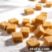 Microwave peanut butter fudge scattered across a rough, white surface.