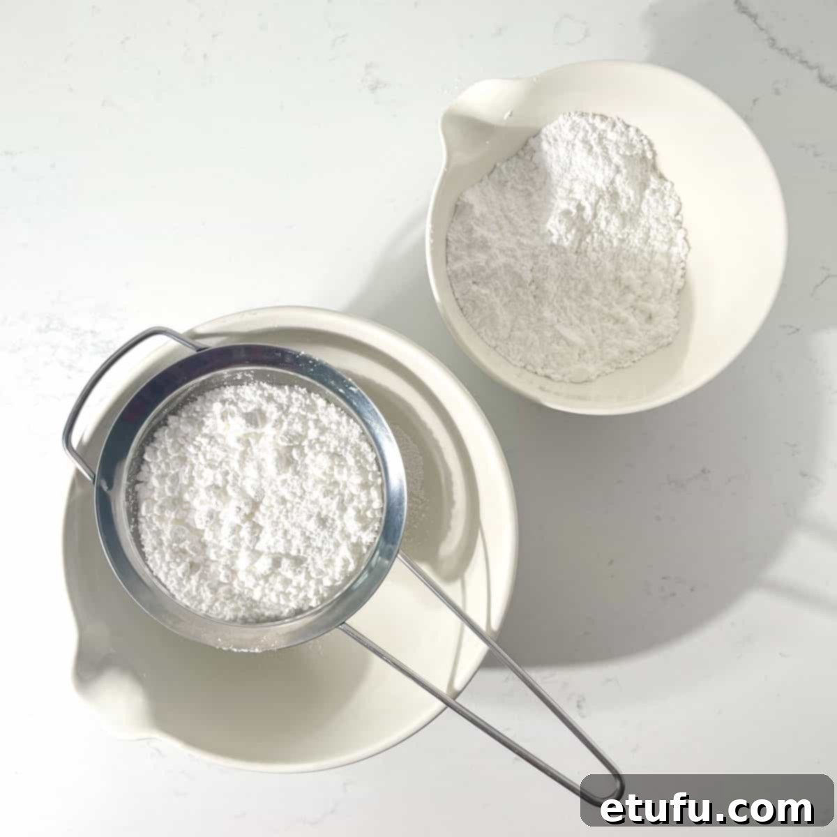 Sifting the icing sugar into a large white bowl for the microwave peanut butter fudge.