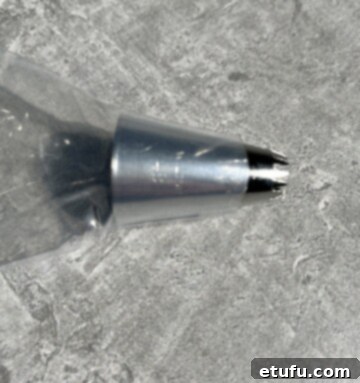 Piping bag with a star tip inserted, demonstrating proper setup for making butter rosettes.