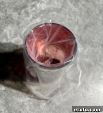 Piping bag secured in a glass, ready for easy filling with softened butter.