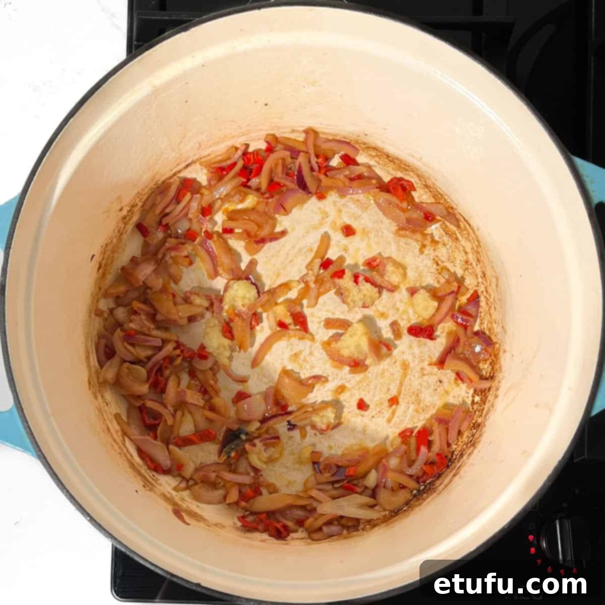 Frying the onions and chillies for the Trinchado in a large pot.