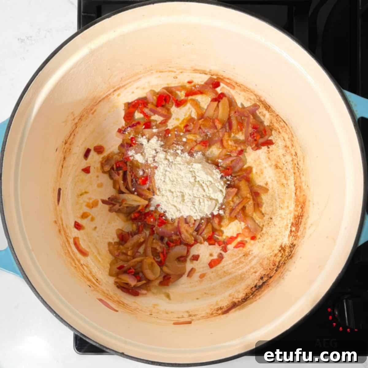 Adding flour to the onions and chillies.