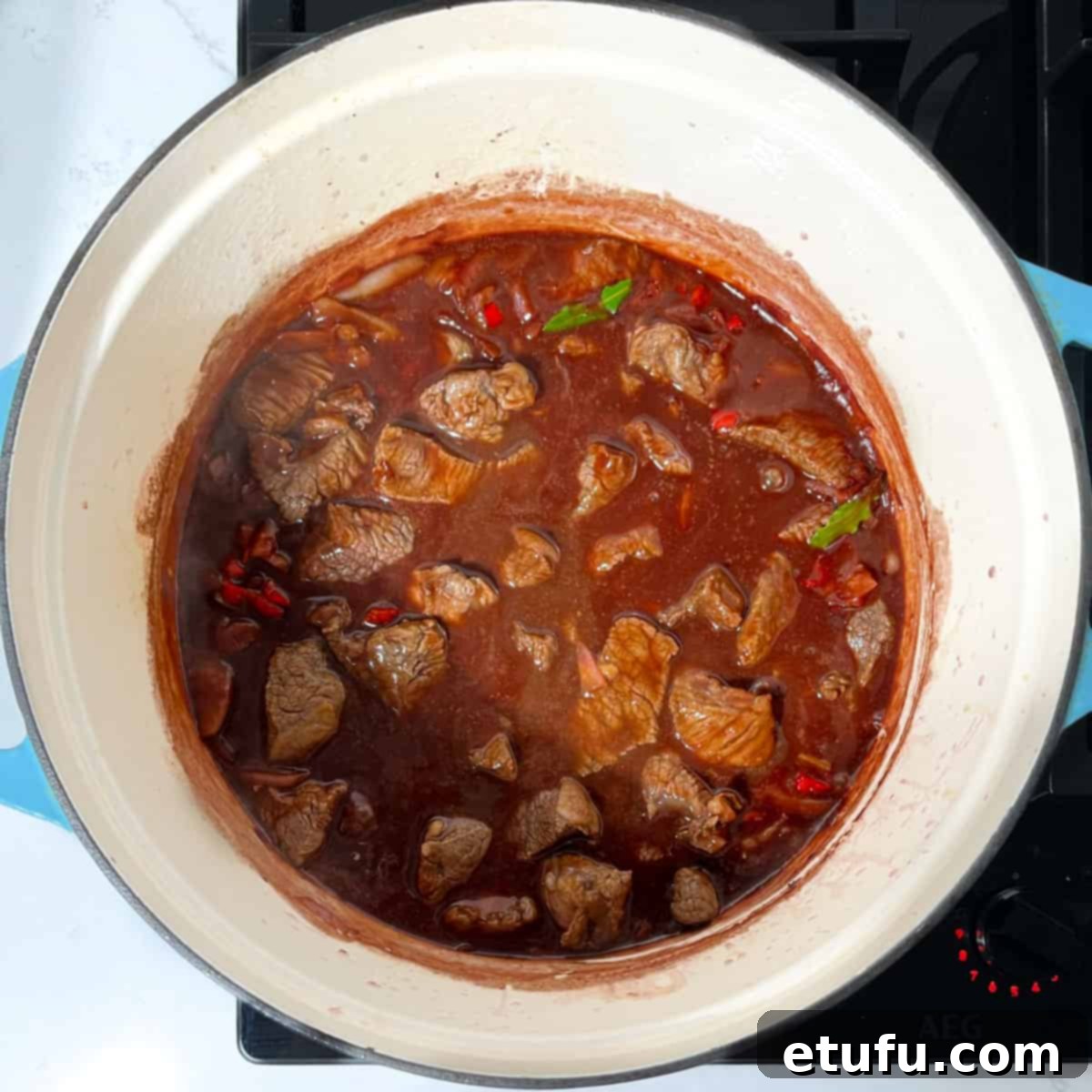 Adding the meat back into the pan with the sauce.