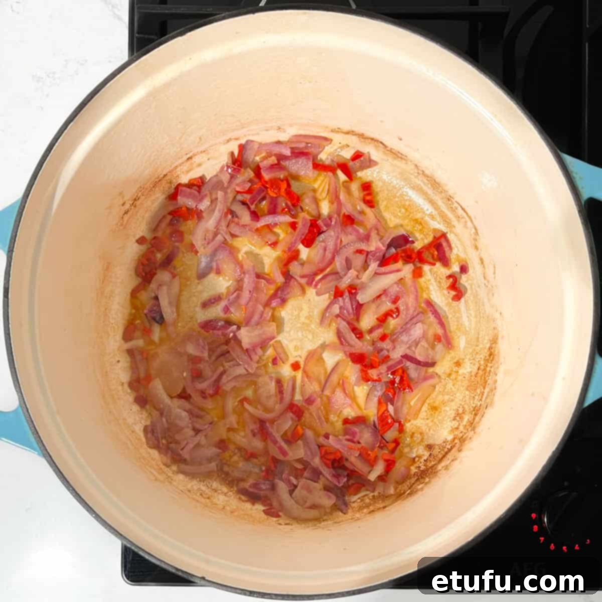 Frying the onions, chilli and garlic in a large saucepan.
