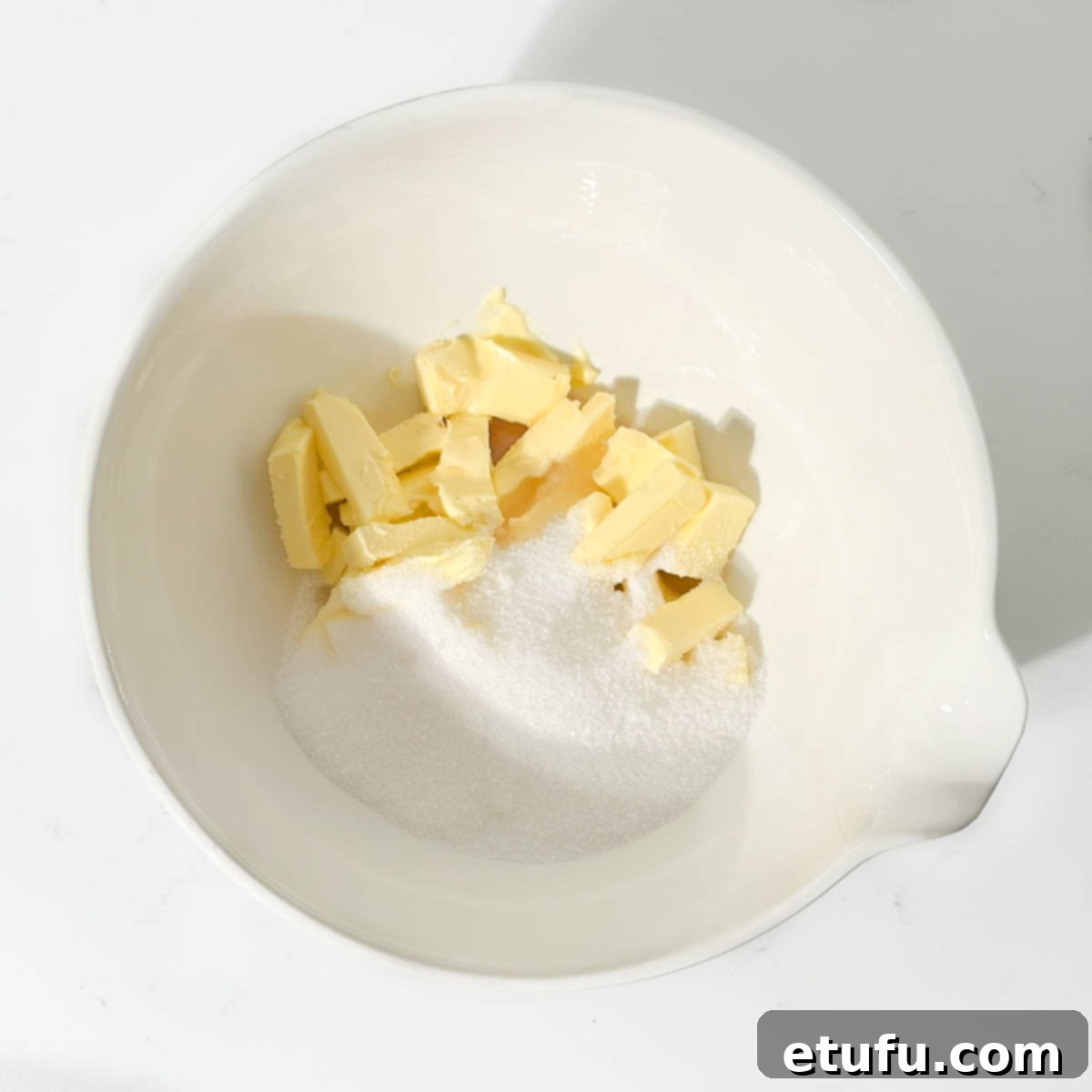 Adding butter and sugar to bowl.