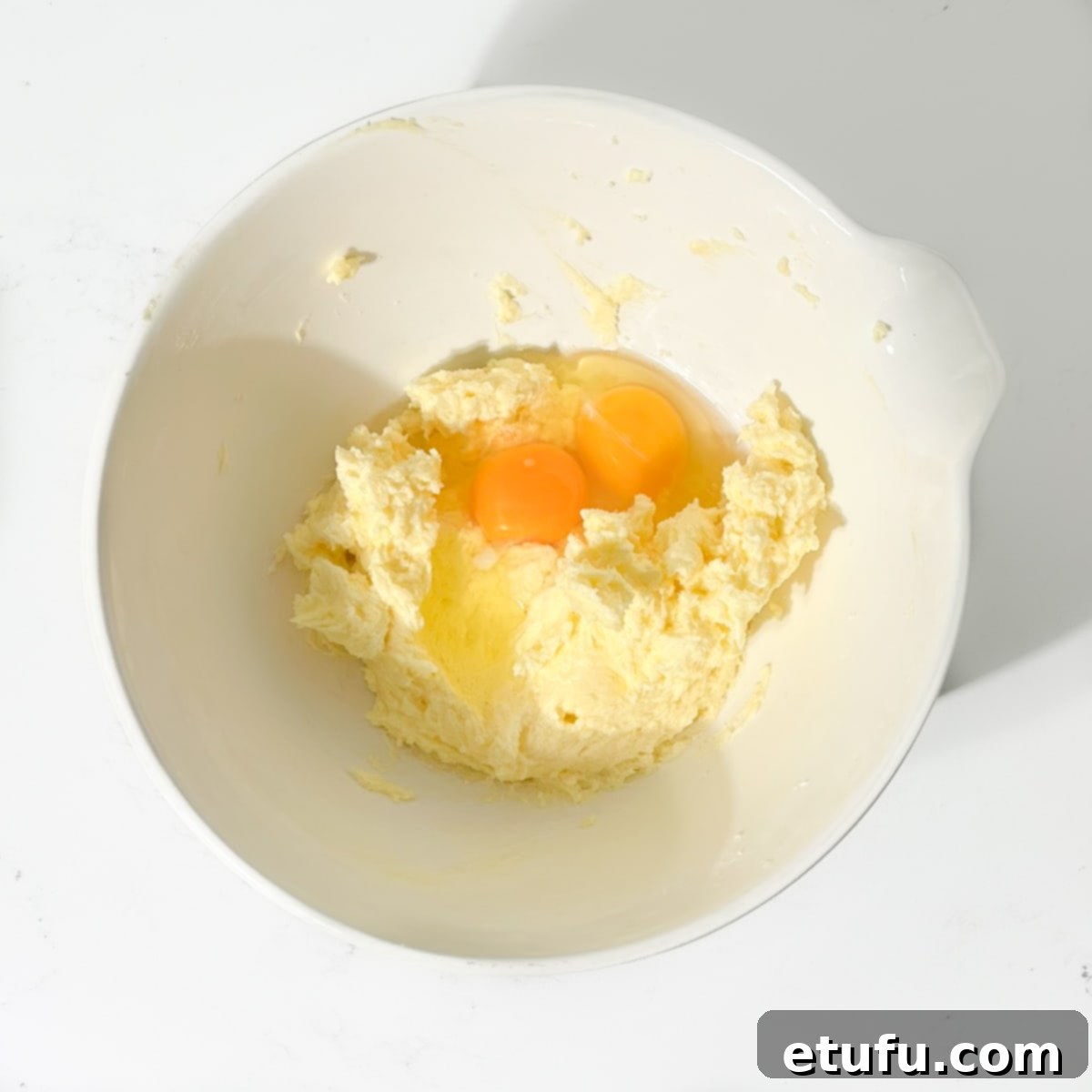 Adding eggs to butter mixture.