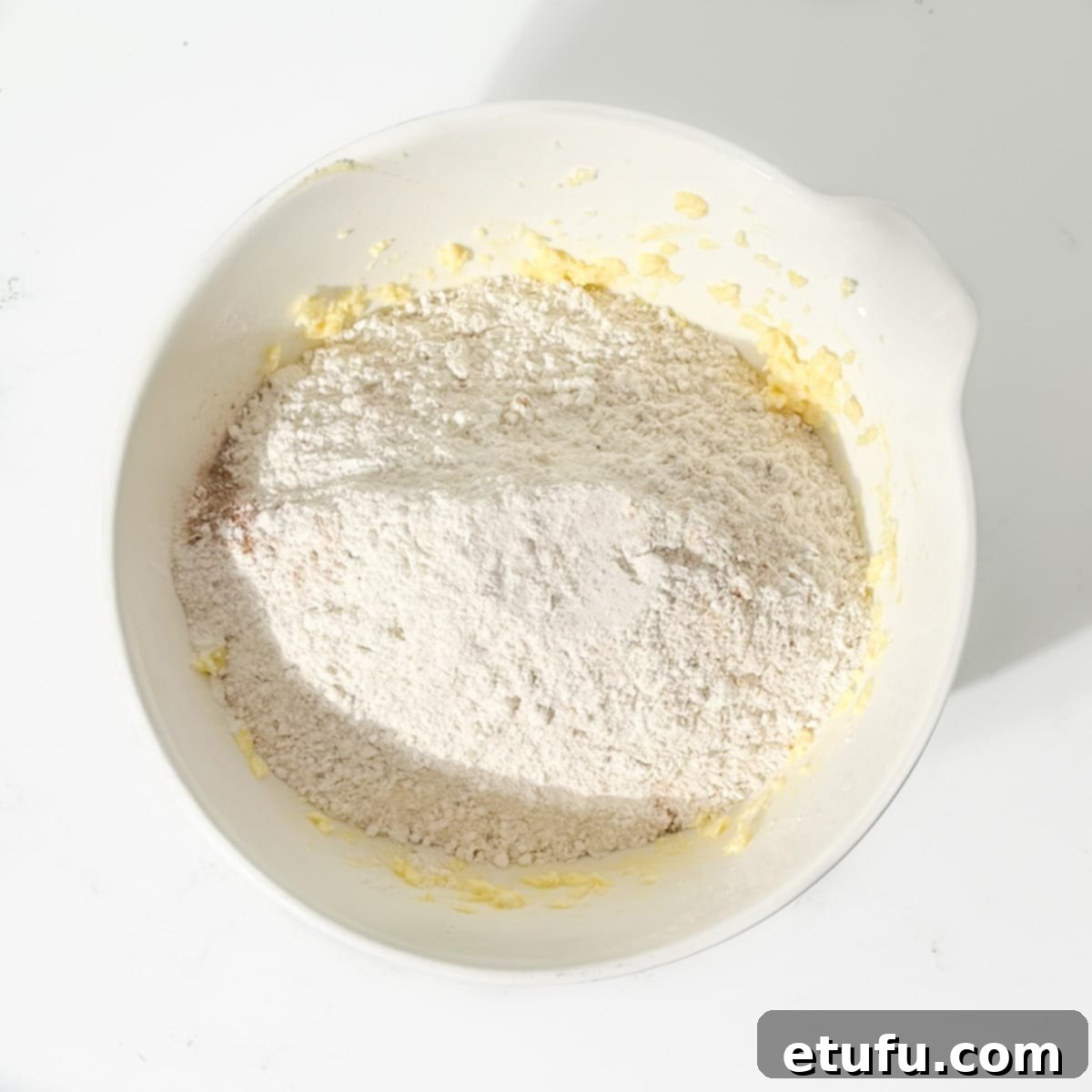 Adding dry ingredients to wet for spice biscuits.