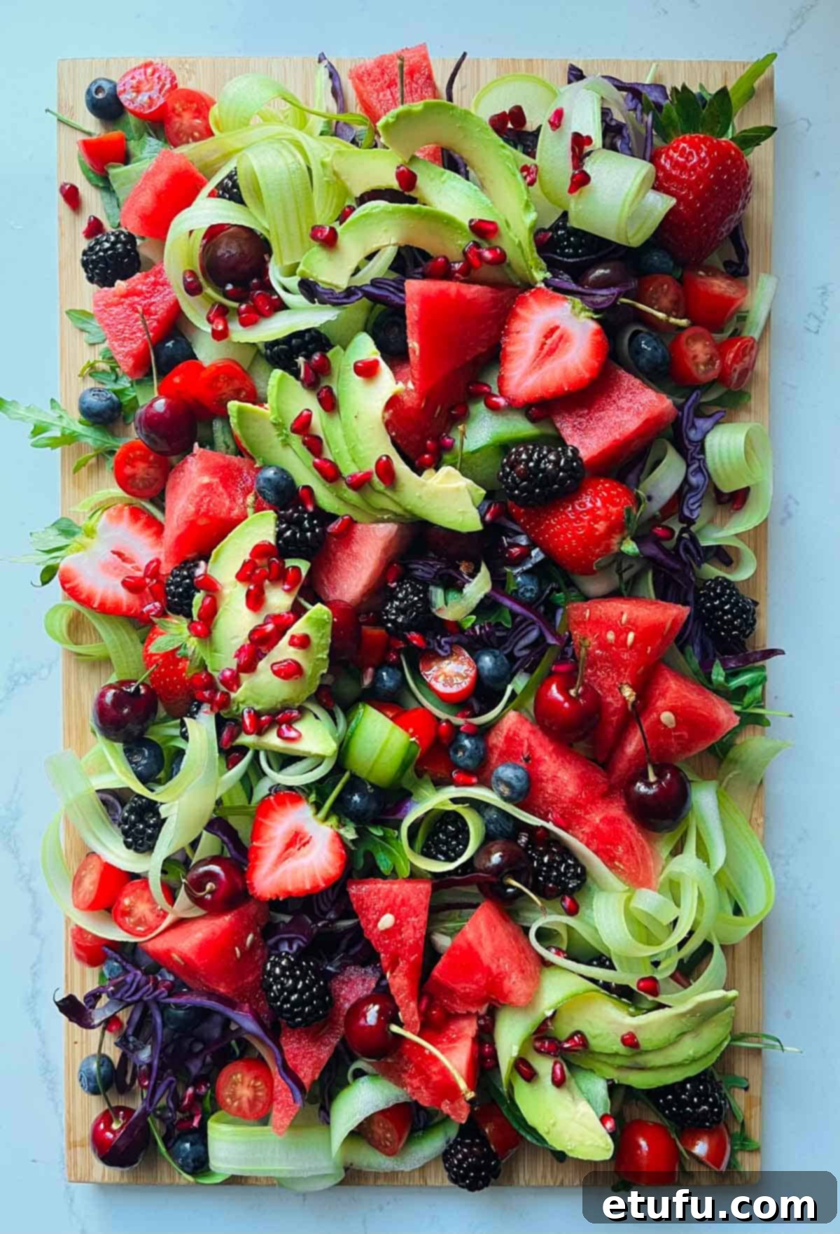 The finished rainbow salad, garnished with sparkling pomegranate seeds and sesame seeds.