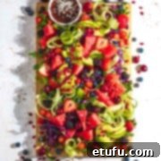 Rainbow salad on a wooden board and a white background.