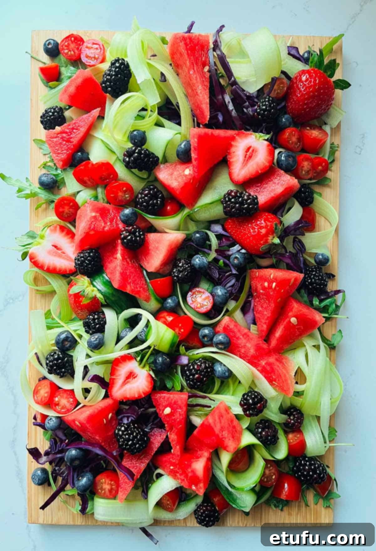 Rainbow salad with various fruits and vegetables, now featuring dark blueberries and blackberries.