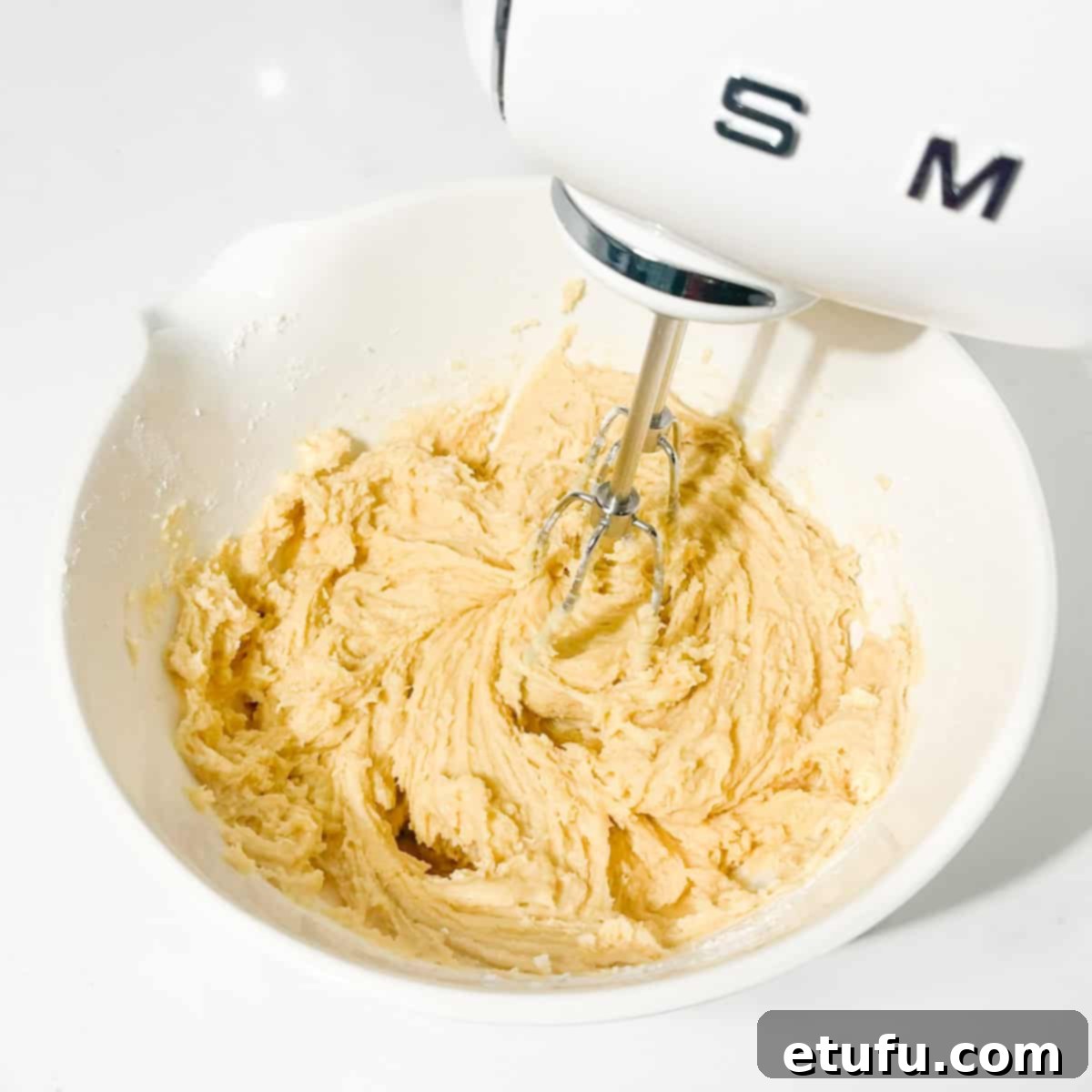 Gently beating the cookie dough after adding dry ingredients, ensuring no overmixing.