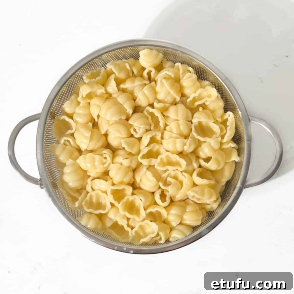 Pasta draining in a colander.
