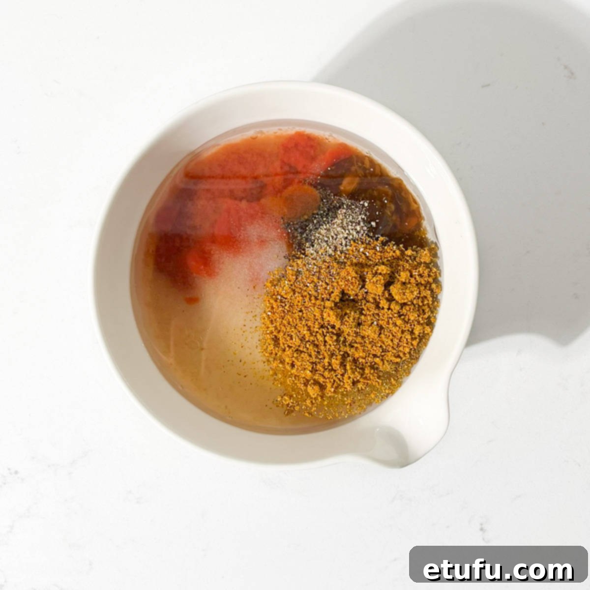 All the ingredients for the curry noodle salad sauce in a small white bowl.