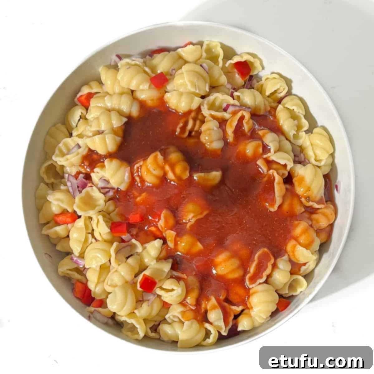 Adding the sauce to the pasta.