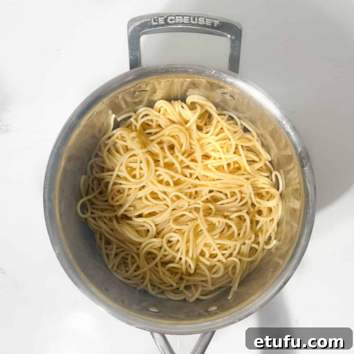 Spaghetti cooking in a large saucepan of boiling, salted water until al dente.