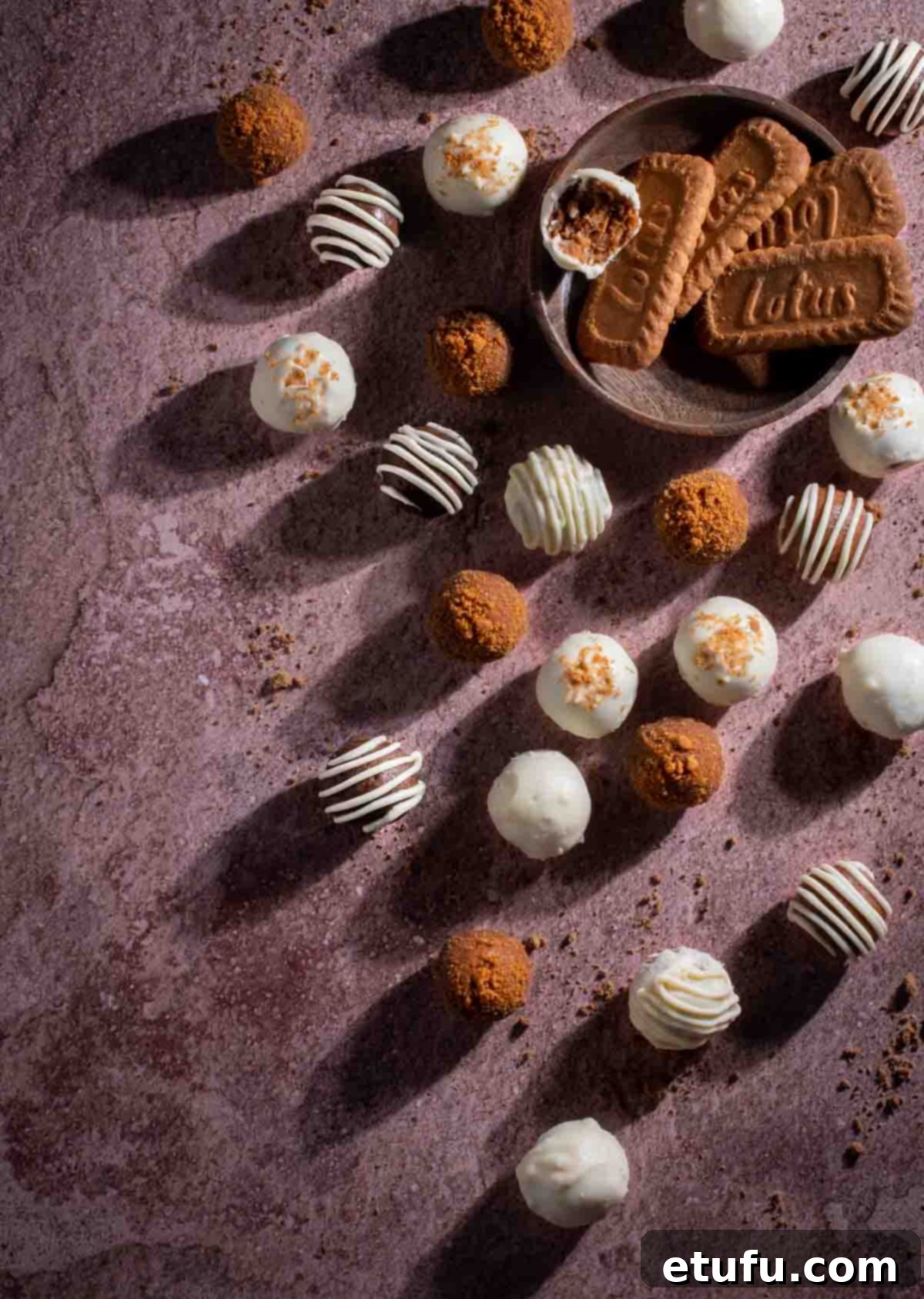 Biscoff truffles decorated in various ways on a mauve background.