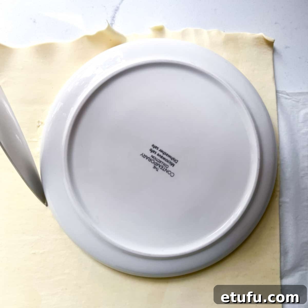 Golden Flaky Creamy Chicken Leek Pies 11 Using a side plate as a template to cut out a round pastry circle from puff pastry.