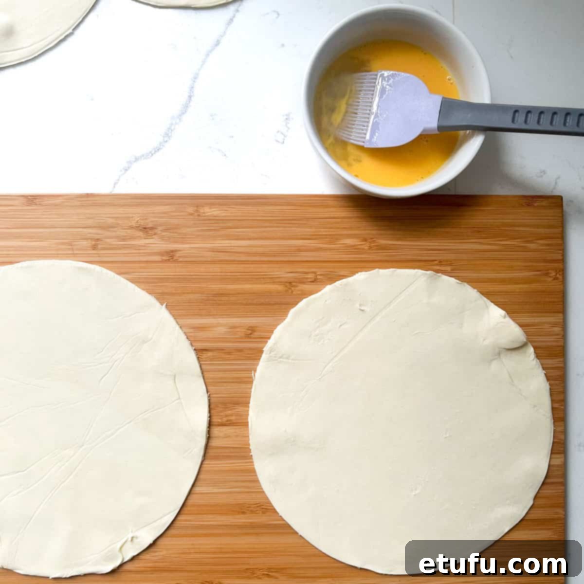 Golden Flaky Creamy Chicken Leek Pies 12 Four perfectly cut puff pastry circles on a wooden chopping board, ready for filling.