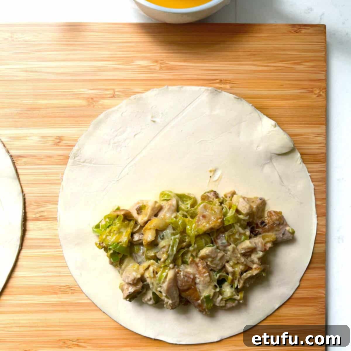 Golden Flaky Creamy Chicken Leek Pies 13 Chicken and leek pie filling neatly scooped onto one half of a pastry circle.