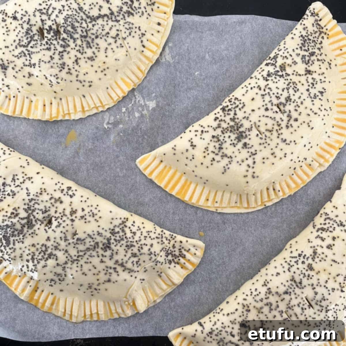 Golden Flaky Creamy Chicken Leek Pies 20 Four assembled chicken and leek pies on a baking sheet, prepared for the oven.