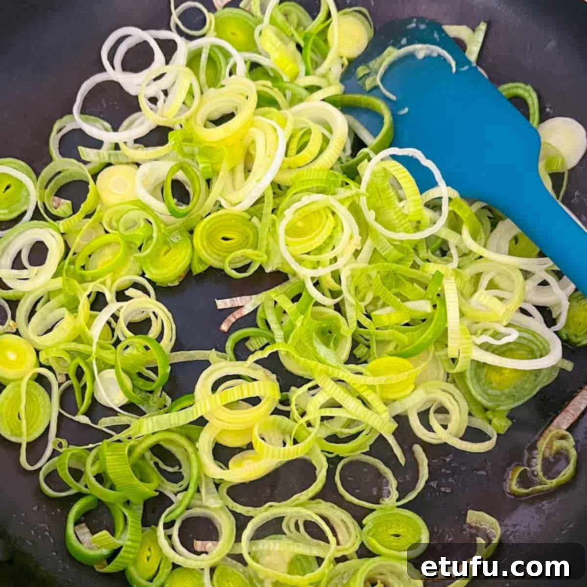 Golden Flaky Creamy Chicken Leek Pies 7 Thinly sliced leeks being gently fried in a frying pan with butter.