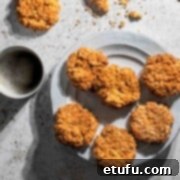 Easy coconut biscuits on a plate with two mugs of coffee.