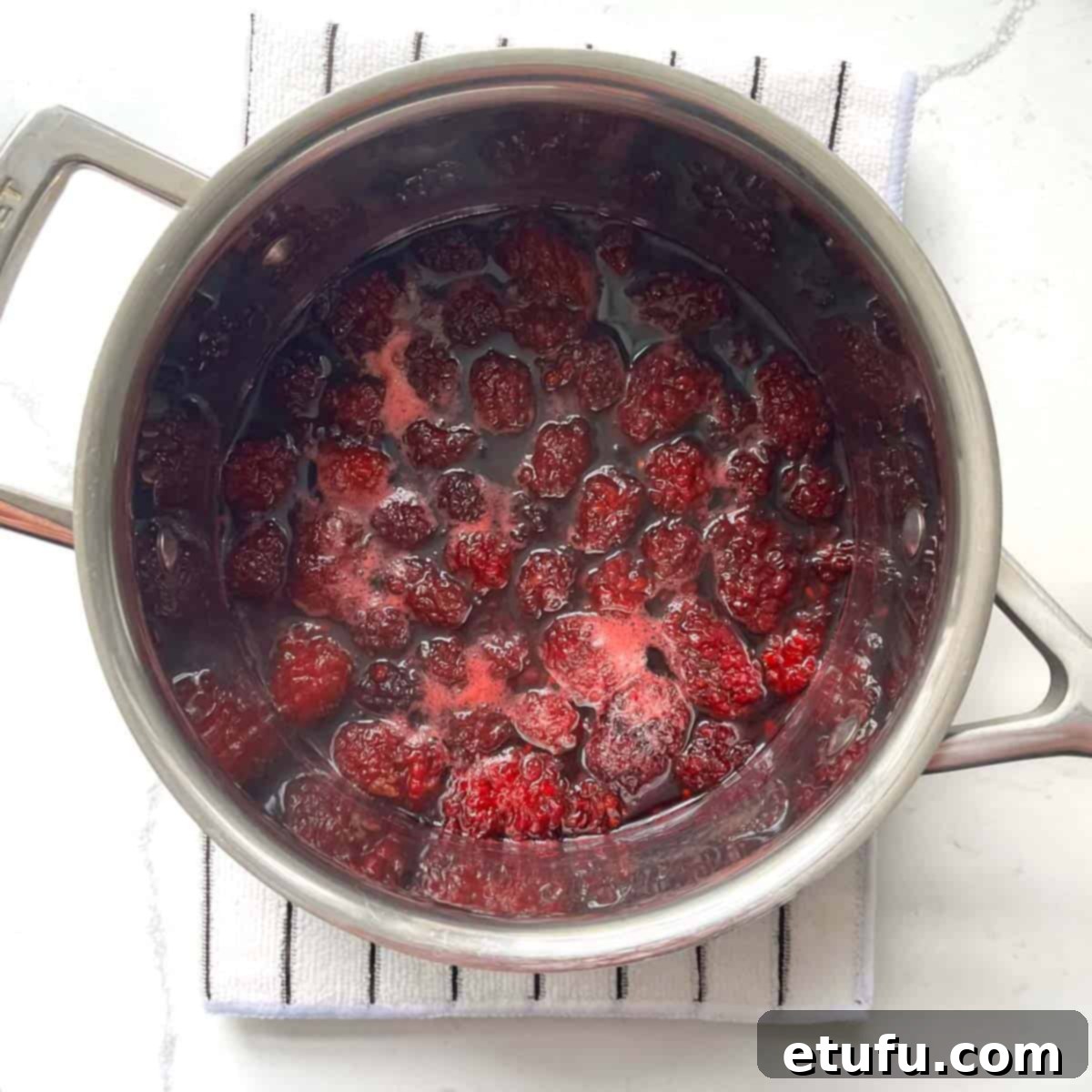 Cooked blackberry simple syrup in a saucepan.
