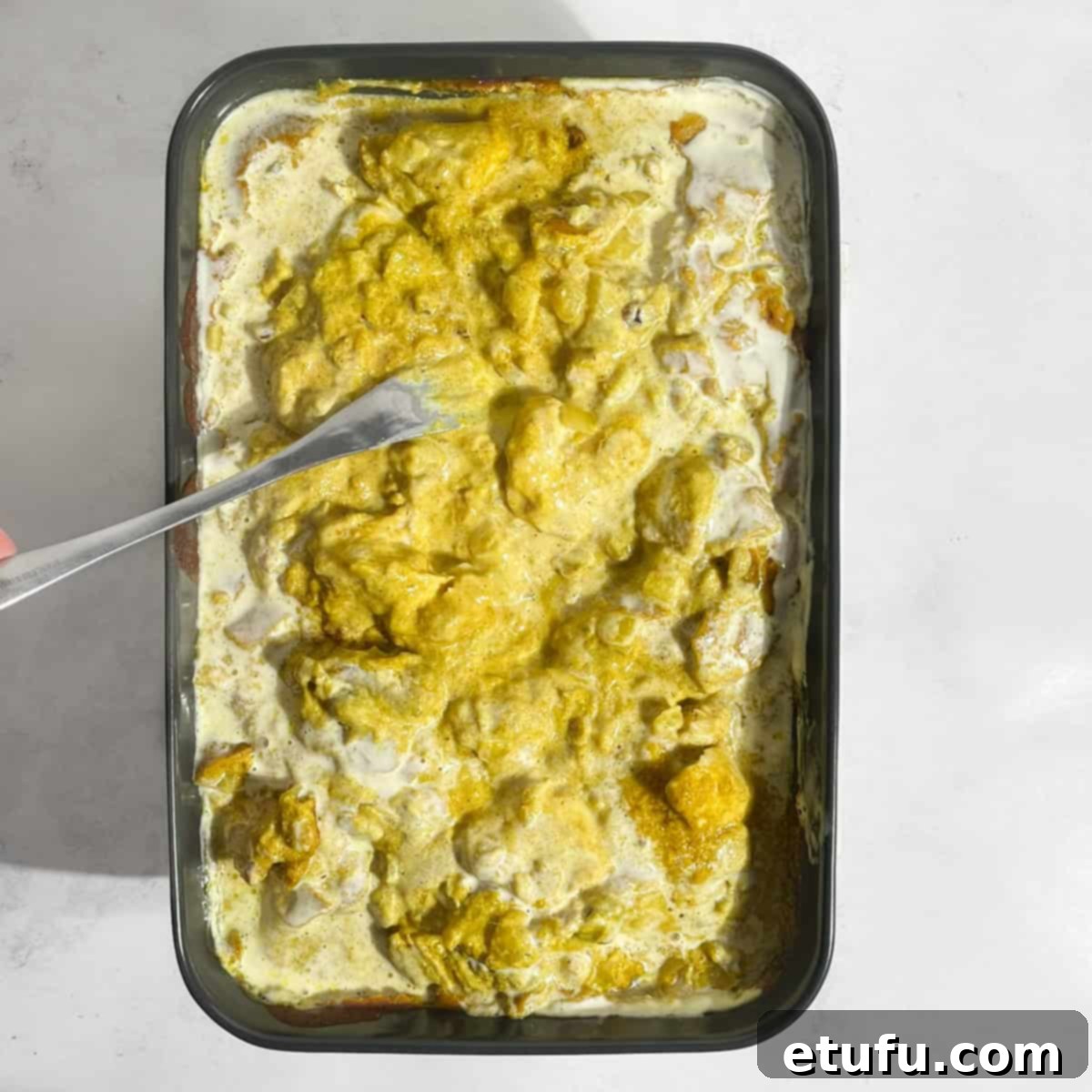 The partially baked Pasanda curry is gently stirred with the cream mixture in the baking dish for a rich, smooth finish.