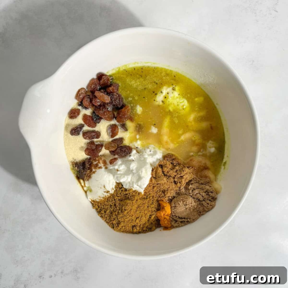 A vibrant mix of Pasanda curry sauce ingredients, combined and waiting in a white bowl.