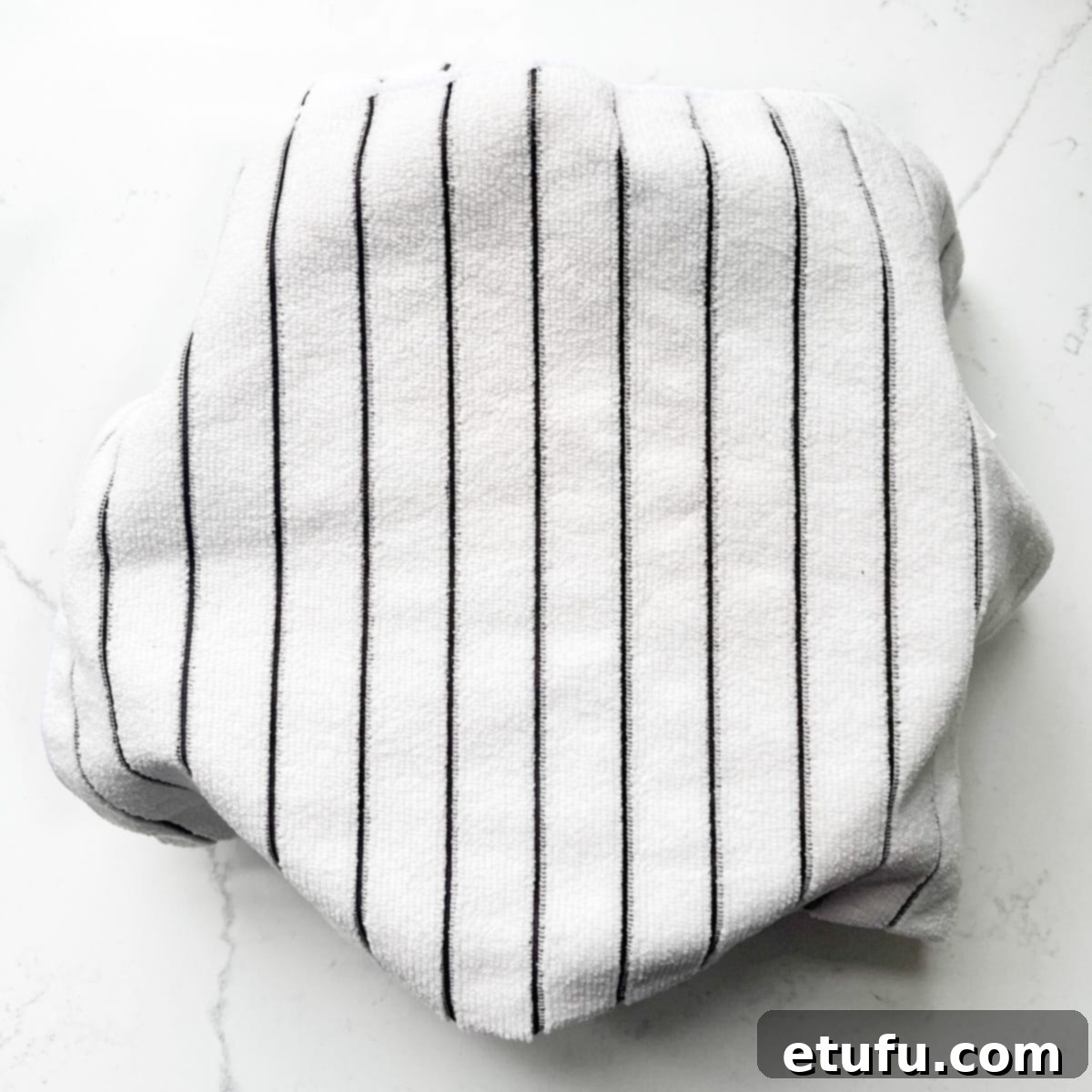 A bowl of rice for the sushi salad covered with a white kitchen towel.