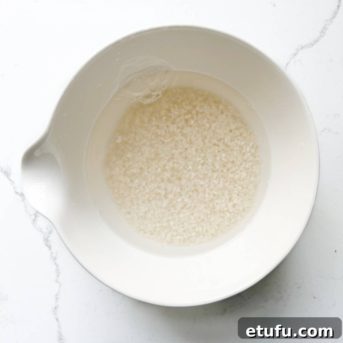 Sushi rice for sushi salad soaking in a bowl.