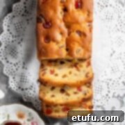 A sliced sultana cake on white doilies.