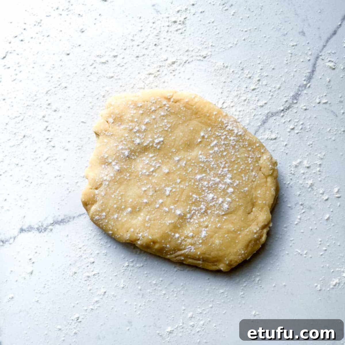 Exquisite French Fruit Tart 12 A ball of pastry dough on a floured work surface.