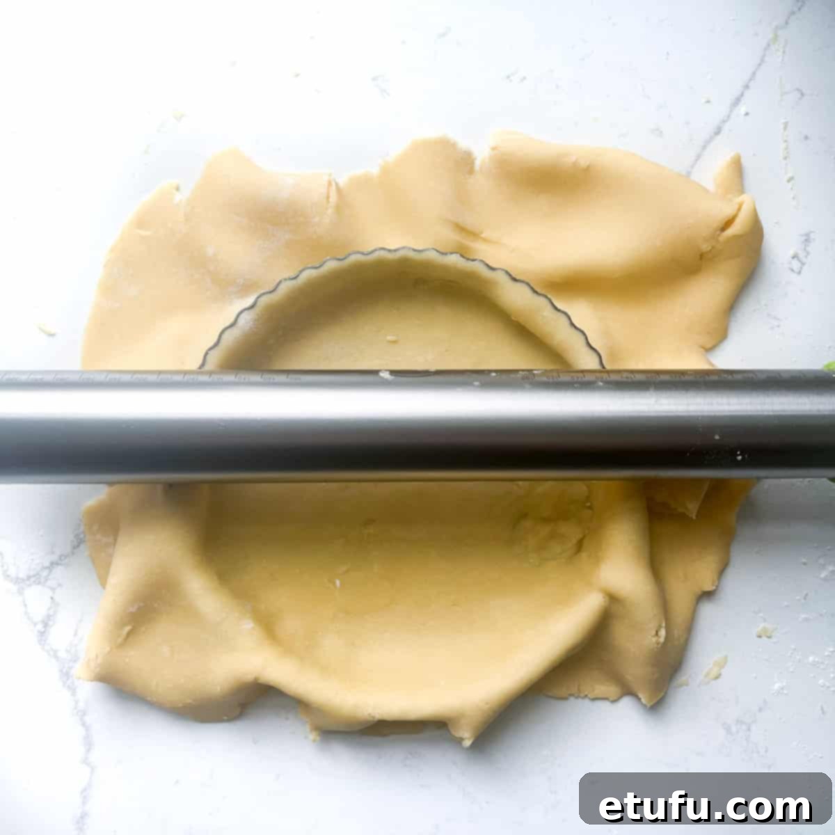 Exquisite French Fruit Tart 17 Rolling a rolling pin over the pastry case to cut off any excess pastry.