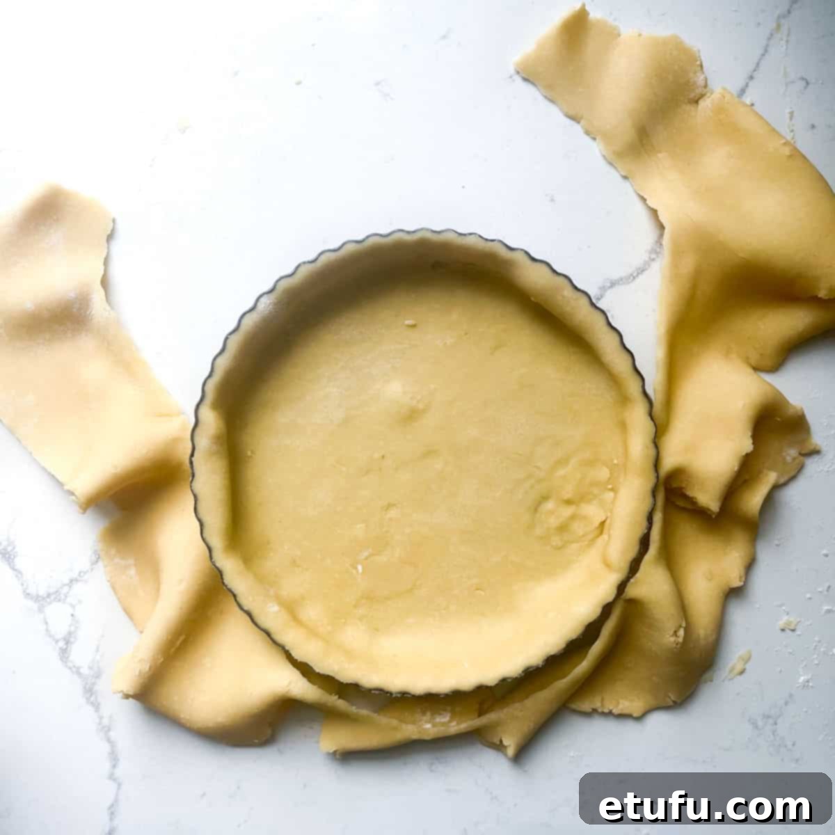 Exquisite French Fruit Tart 18 Removing excess pastry from around the tart tin.