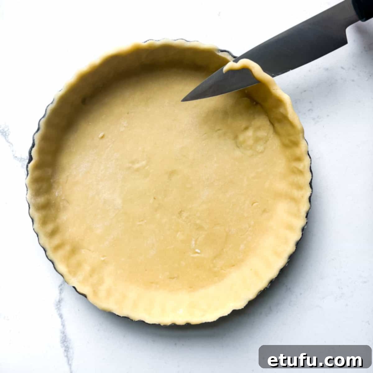 Exquisite French Fruit Tart 19 Cutting off excess pastry with a small knife.