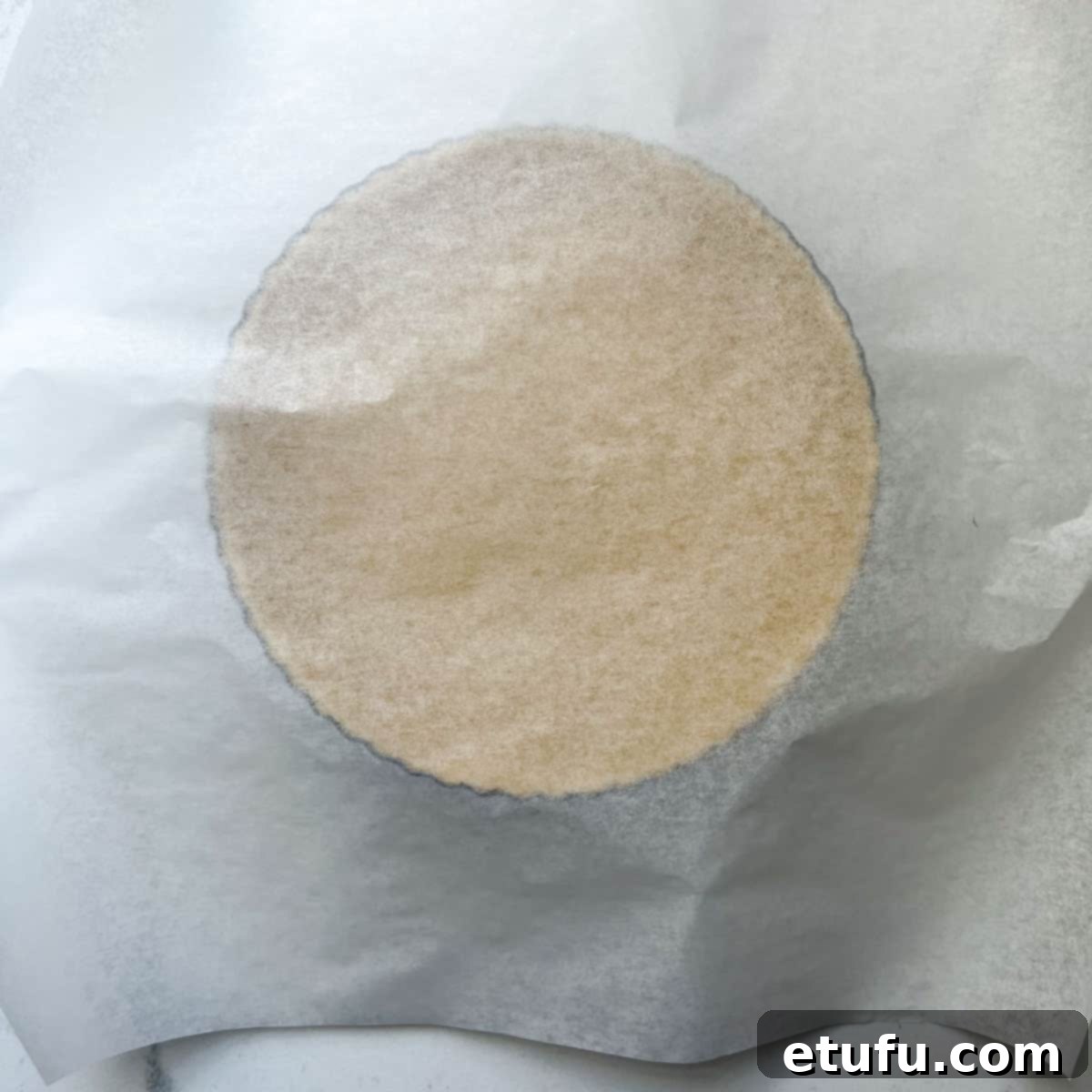 Exquisite French Fruit Tart 20 Draping a piece of parchment paper over an unbaked pastry case.