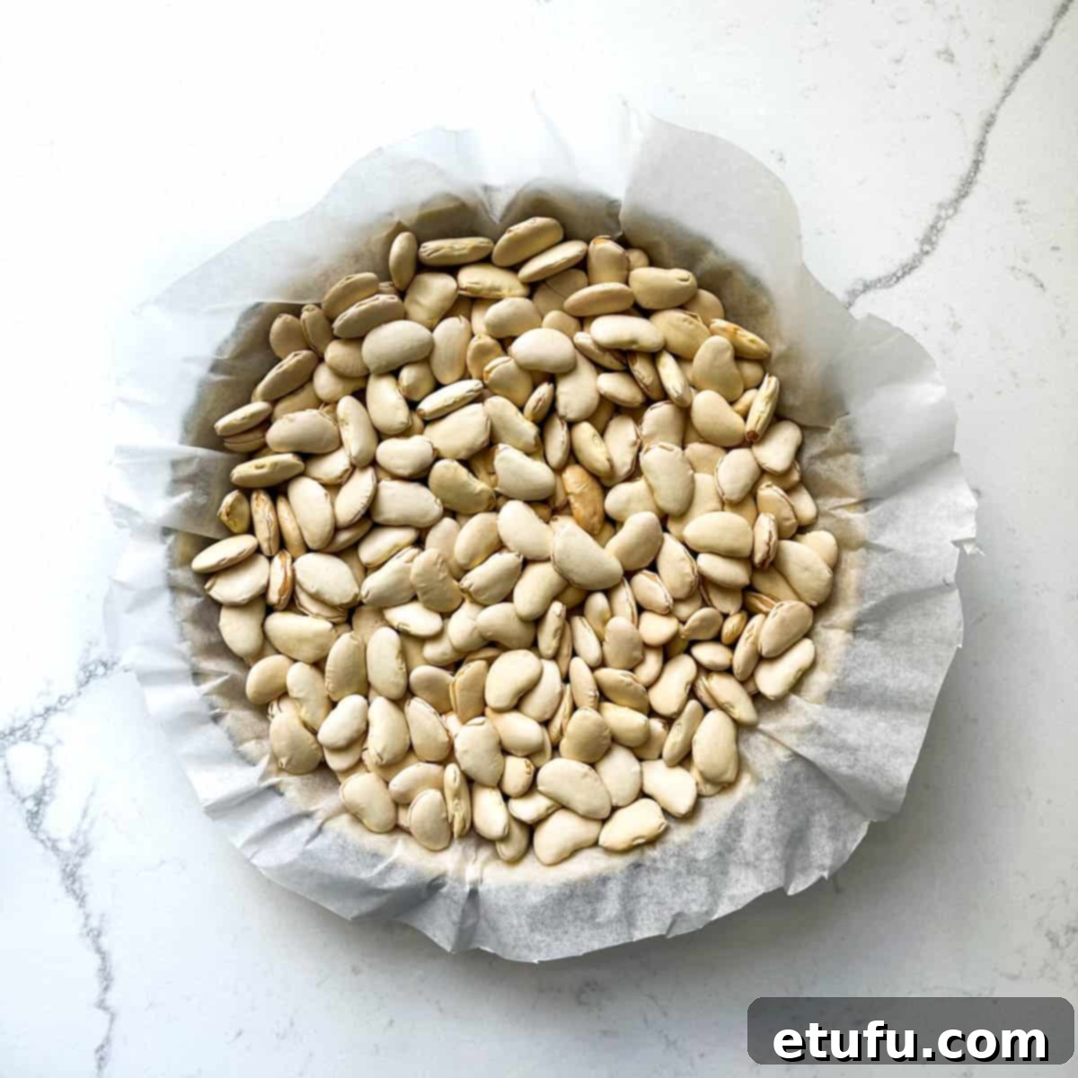 Exquisite French Fruit Tart 21 Baking beans in a tart tin.