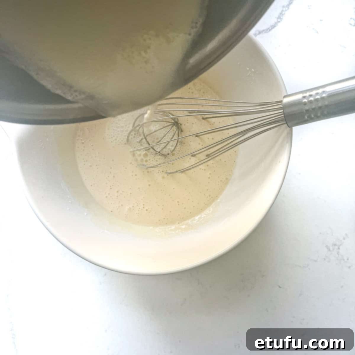 Exquisite French Fruit Tart 31 Pouring all the milk mixture to the eggs in a large mixing bowl.