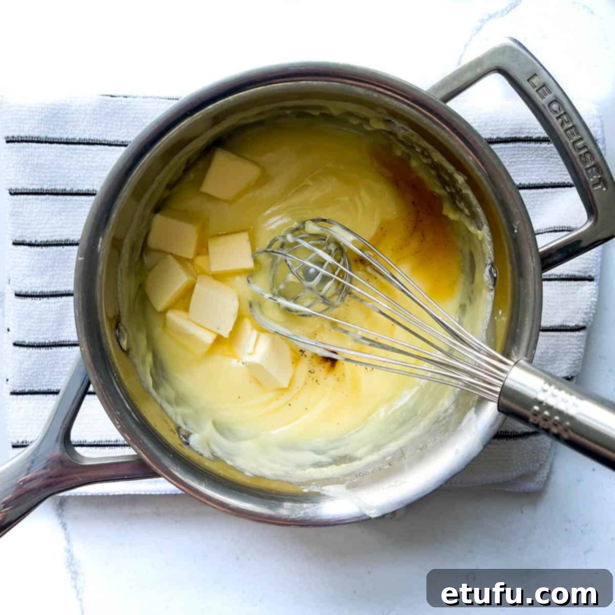 Exquisite French Fruit Tart 34 Adding butter and vanilla to the creme pattisiere in a saucepan.