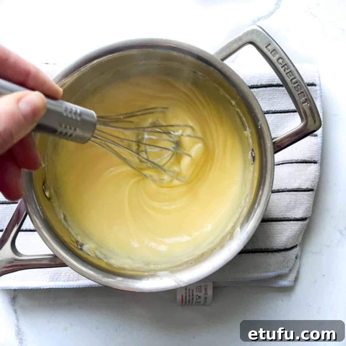 Exquisite French Fruit Tart 35 Whisking butter and vanilla into creme pattisiere in a small saucepan.